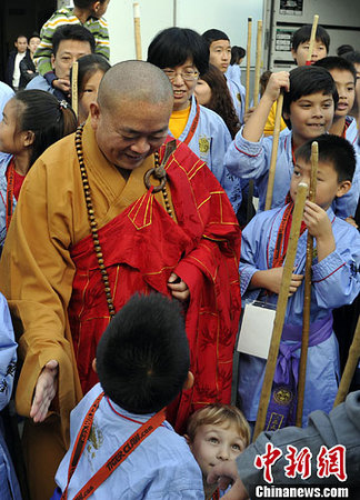 圖為少林寺釋永信方丈與參加武術(shù)交流的兒童們交談。中新社發(fā) 毛建軍 攝