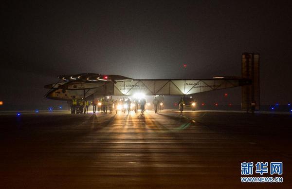 31日凌晨，工作人員在停機坪上推著太陽能飛機向臨時搭建的專用機庫前行。