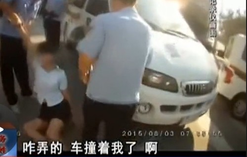 在拉扯中，女子撞到警車上。