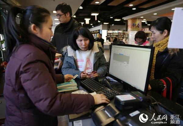 書店服務員幫助市民查閱該書是否可外借。