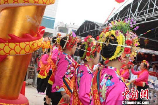 6月2日，福建泉州蟳浦媽祖宮廟——順濟宮重修落成慶典儀式舉行，蟳埔女頭上戴著鮮花串成的“簪花圍”成了“移動的花海”。　廖靜 攝