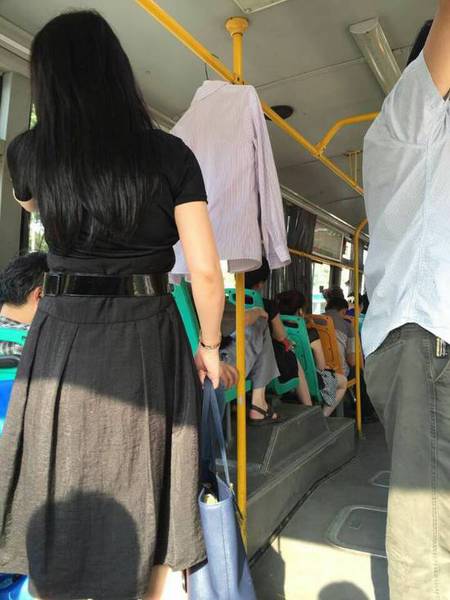 年輕女子在公交車廂內晾曬衣服