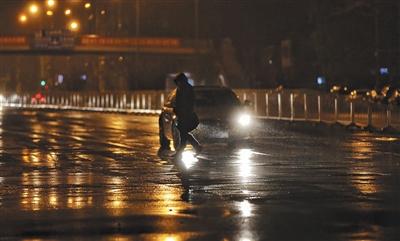 昨日，大望路，行人正在冒雨過人行道。 新京報(bào)記者 王飛 攝