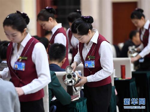 3月6日，北京華北賓館的女服務員在民盟、無黨派人士界委員聯(lián)組會上倒水。在兩會會場內(nèi)外，女代表、女委員、女工作人員、女記者在工作中盡職盡責，展現(xiàn)著自己的風采。 新華社記者張鐸攝