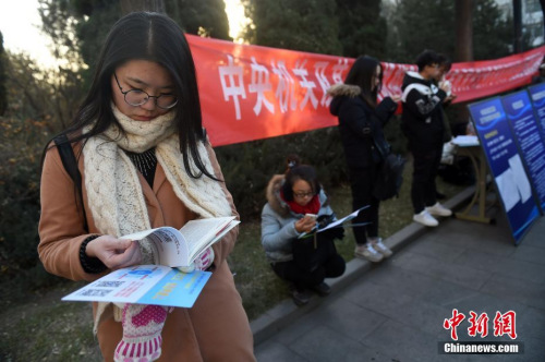 資料圖：2016年11月27日，山西太原一國考考點，考生在考場外看書復(fù)習(xí)。武俊杰 攝