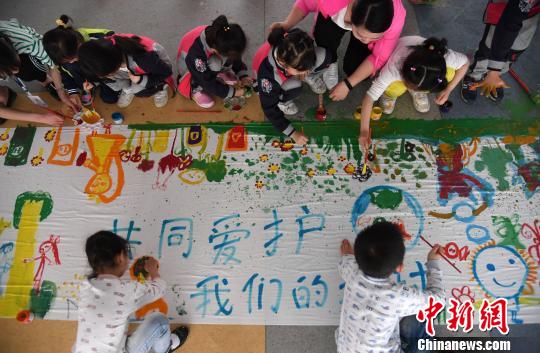 4月19日，江西省新余市蓓蕾幼兒園的小朋友在創(chuàng)作保護(hù)地球主題繪畫作品。　周亮　攝