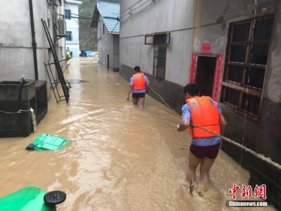 圖為浙江省麗水市遂昌縣民警在積水中準備營救居民。