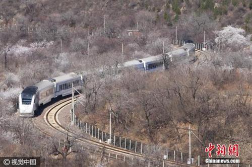 2017年3月26日，北京居庸關長城腳下，山花漸次盛開，和諧號列車行駛在花海中，駛向春天，美如畫卷。王明允 攝 圖片來源：視覺中國