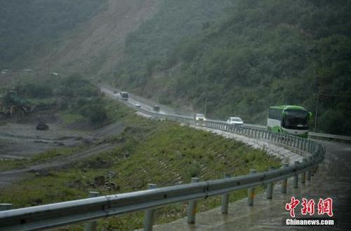 大客車載著游客冒雨撤離。 <a target='_blank' href='http://www.chinanews.com/'>中新社</a>記者 劉忠俊 攝