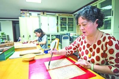 武漢市圖書館的古籍修復非遺傳承人賀琳在補缺口