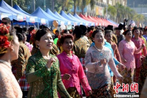 踩街隊伍在美食街上穿行表演，整個活動現場成為歌舞的海洋。　張金川　攝