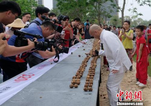 黎偉軍手劈核桃現場吸引不少人圍觀?！〕叹皞?攝