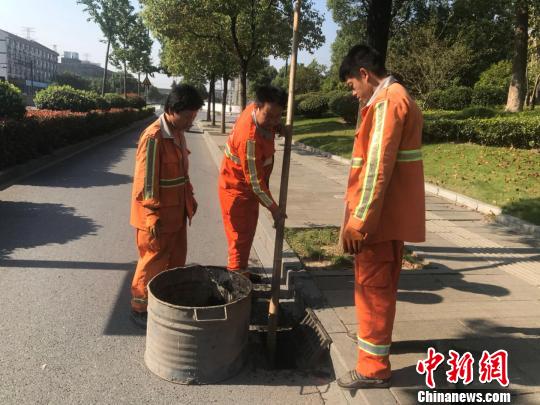 浙江省杭州市西湖區市政監管科工作人員潘旭陽(左二)在清理淤泥。　胡哲斐 攝