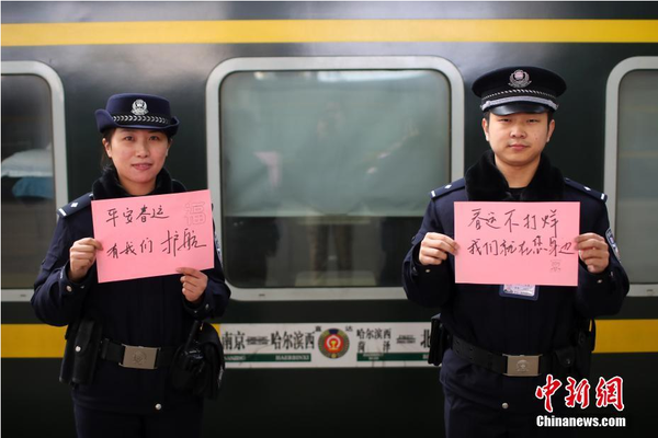 2月1日，隨著春節臨近，南京鐵路公安處南京站派出所的民警在紙上寫下“平安春運，有我們護航”、“天下無賊是我們最大的心愿”、“平安歸途么么噠”等話語，用別樣的方式給旅客們送上溫馨的新年祝福。圖為南京火車站站臺上的值班民警送出溫馨祝福語。中新社記者 泱波 攝