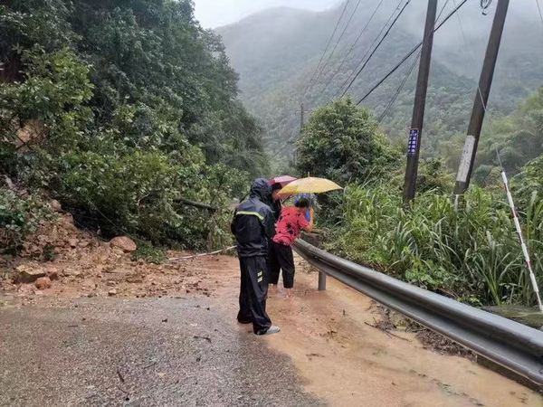 寧海縣澄深村支書張林恩攙扶吳菊芳走過塌方點