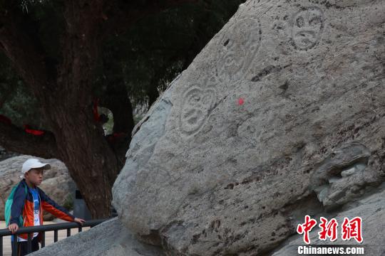 在寧夏賀蘭山巖畫景區內，這在觀看巖畫的游客?！∮诰?攝