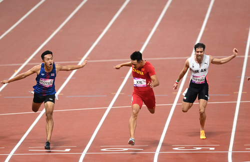 中國選手謝震業(yè)（中）沖過終點(diǎn)。