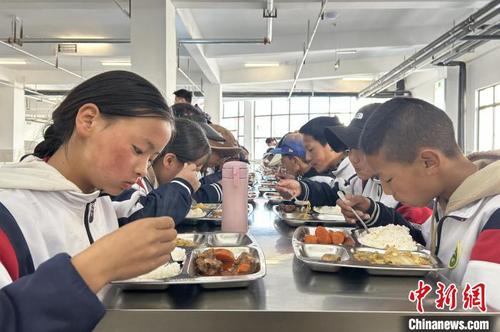 近日，色達縣中學東校區，學生們在食堂用餐。中新社記者 王鵬 攝